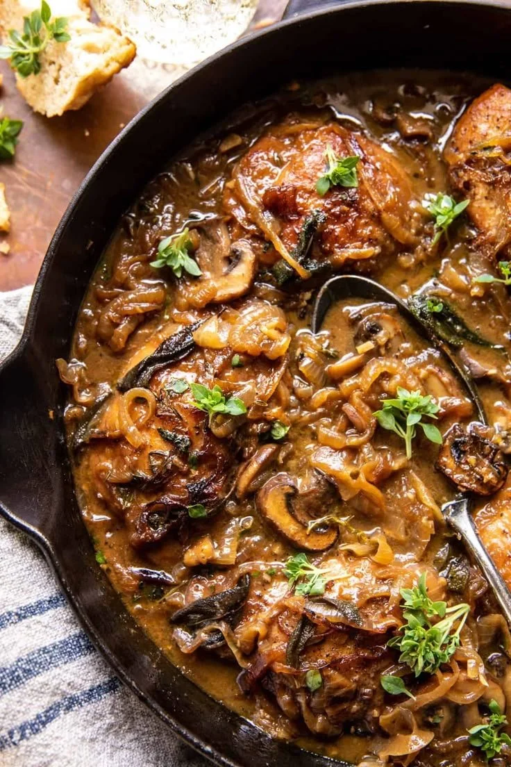 Cider braised chicken with caramelized onions on a plate