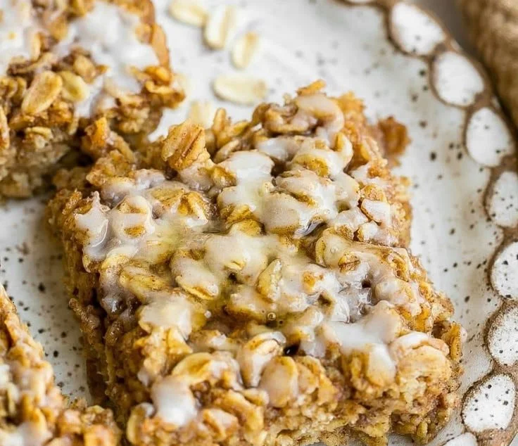 Baked cinnamon roll oatmeal topped with icing in a dish