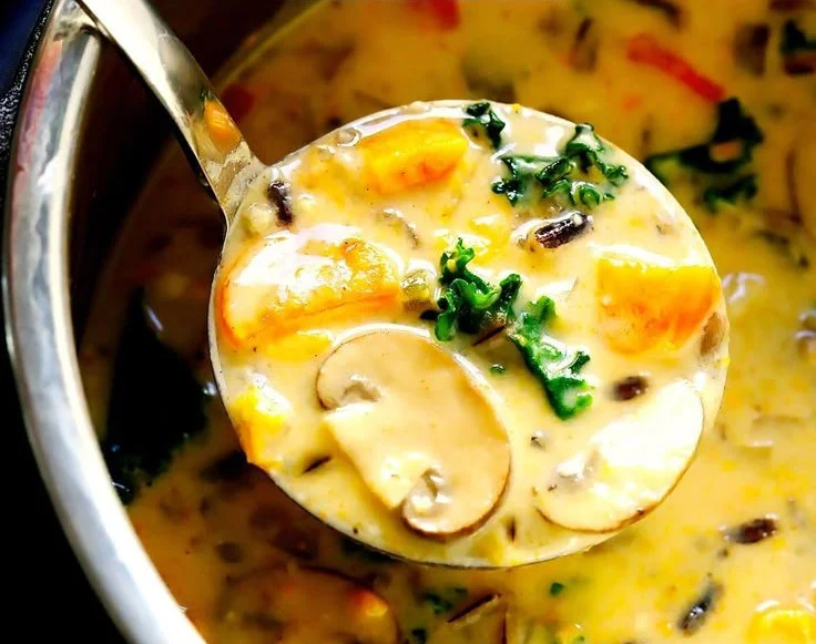 Bowl of cozy autumn wild rice soup topped with herbs and vegetables