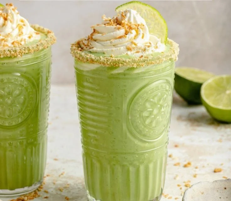 Creamy coconut key lime pie smoothie in a glass garnished with lime slices