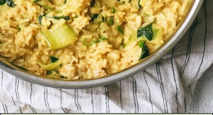 Creamy coconut milk turmeric rice served in a bowl with herbs