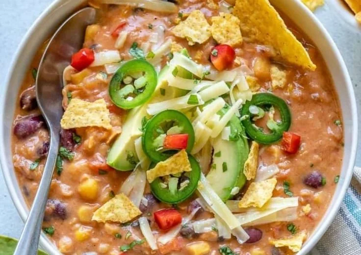 Bowl of Decadent Lentil Tortilla Soup topped with tortilla strips and cilantro