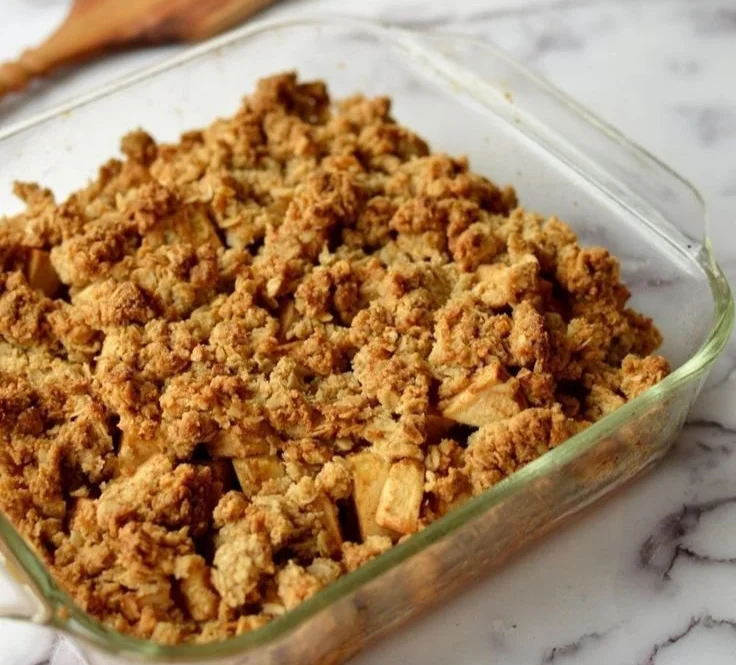 Delicious easy apple crumble served in a baking dish with a scoop of ice cream