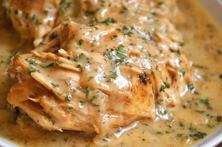 Easy Crockpot Chicken served with creamy gravy in a bowl.