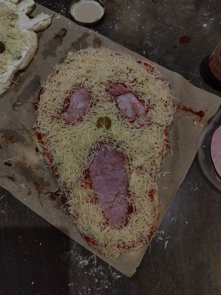 Delicious Ghostface Pizza topped with fresh ingredients and a spooky design