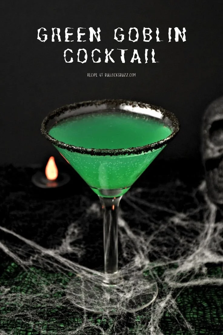 Green Goblin Halloween cocktail in a spooky glass garnished with a gummy worm