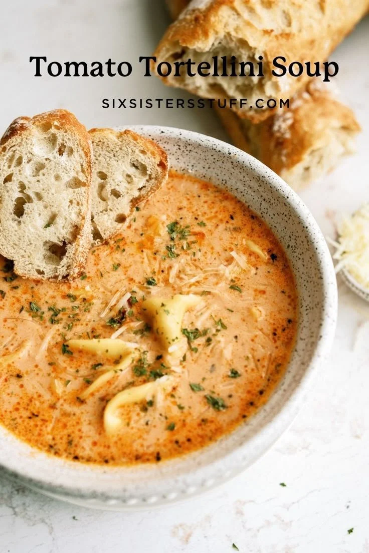 Bowl of delicious Tomato Tortellini Soup garnished with fresh herbs