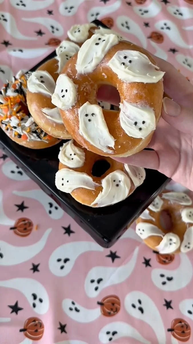 Spooky ghost donuts decorated with frosting and writing gel for Halloween