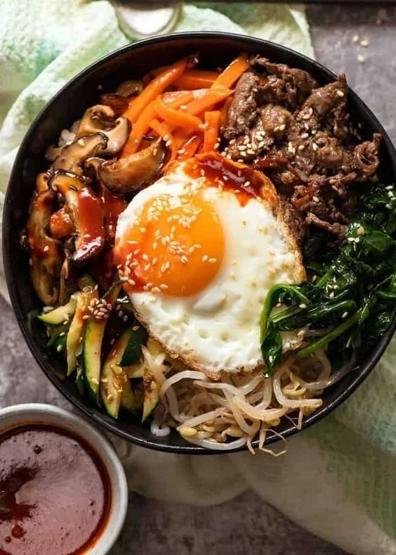 Colorful Bibimbap Korean rice bowl with assorted vegetables, meat, and sauce
