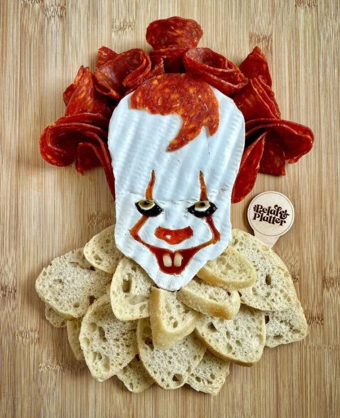A festive charcuterie board featuring creative Halloween snacks and treats.