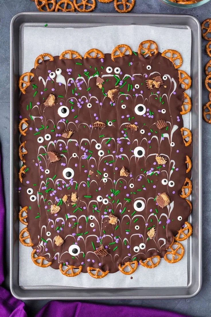 Homemade pretzel bark topped with M&Ms and Halloween decorations