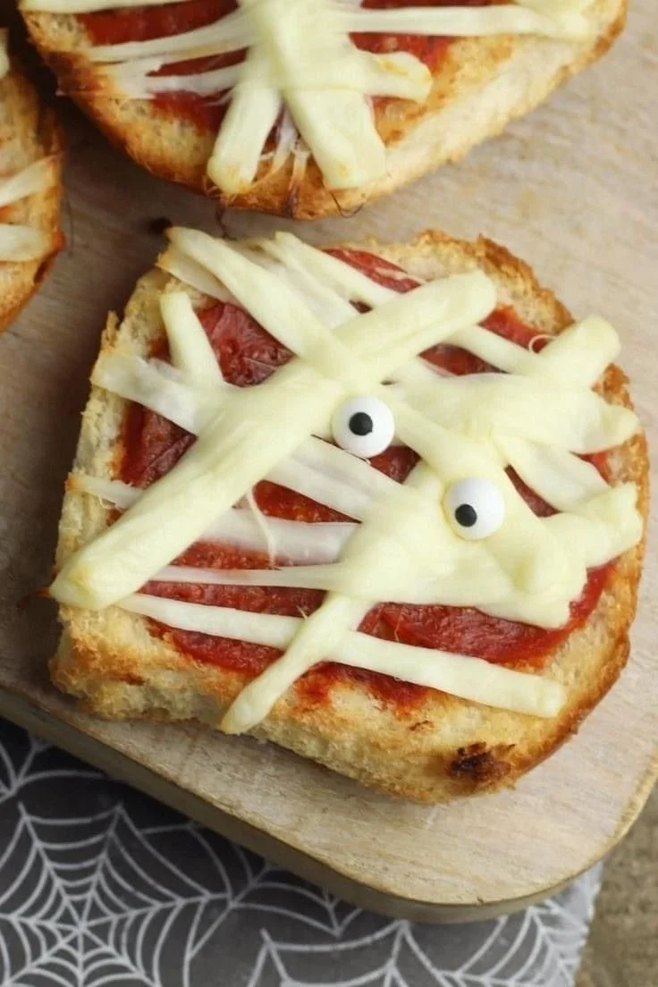 Delicious spooky mummy pizza perfect for Halloween kids' lunch.